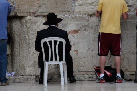 Nebeneinander: Strenggläubige und andere Israelis stehen nebeneinander und stecken ihre Papier-Botschaften in die Ritze der Mauer.