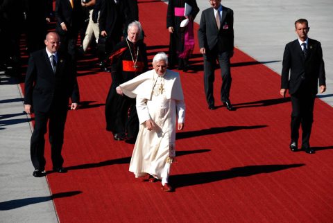 Der Papst und Kardinal Wetter schreiten den roten Teppich entlang.